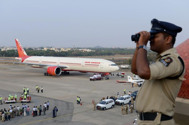 (FILES) In this file photo taken on March 15, 2016, an Indian policeman watches over Begumpet Airport as an Air India Boeing 777 (back L) sits on the tarmac at an airshow in Hyderabad.
India's airports are struggling to cope with a massive surge in passenger numbers and billions of dollars must be spent to boost their capacity, analysts have warned.
 / AFP PHOTO / NOAH SEELAM / TO GO WITH India-economy-aviation,FOCUS by Vishal Manve