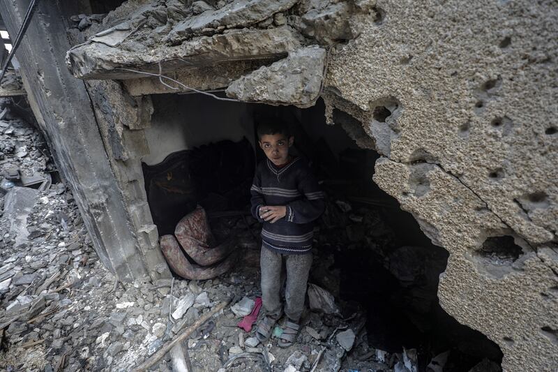 A Palestinian boy stands among the rubble of a destroyed house following an Israeli air strike, in Deir Al Balah, southern Gaza Strip. EPA
