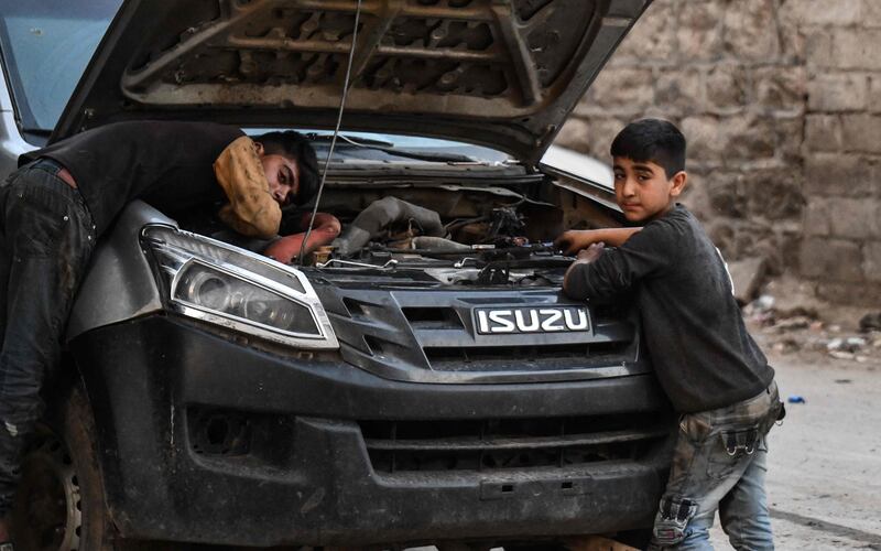 Young Syrian boys work at a car repair shop in the town of Jandaris, in the countryside of the north-western city of Afrin in the rebel-held part of Aleppo province, a day before the annual World Day Against Child Labour.