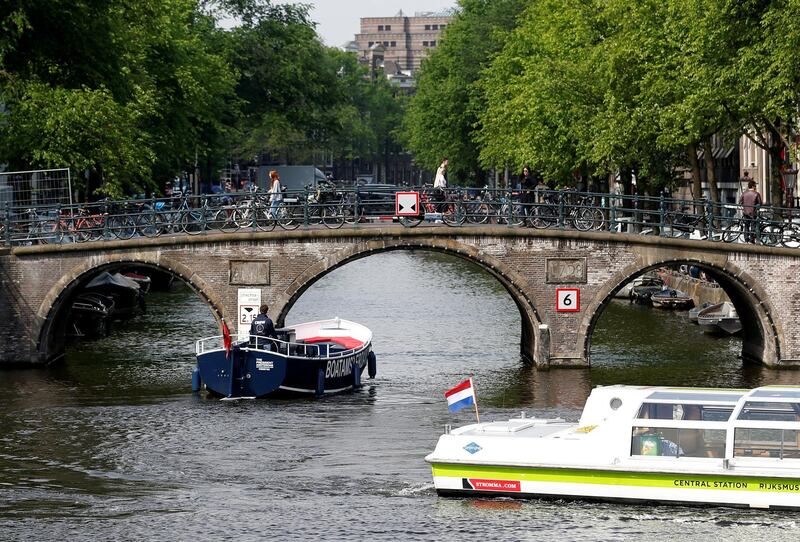 FILE PHOTO: Tourists boats pass on a canal in Amsterdam, Netherlands, May 16, 2018. Picture taken May 16, 2018.  REUTERS/Francois Lenoir/File Photo