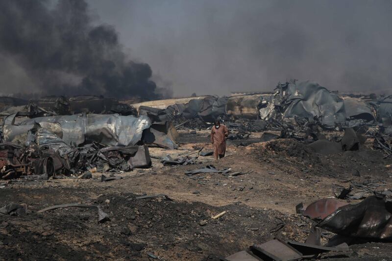 epa09012338 A man surveys the scene of a fire at Islam Qala Border near Iran, in Herat, Afghanistan, 14 February 2021. A fire erupted near the Iranian border in Islam qala area, disrupting power supplies and causing millions of dollars of damage. At least  500 vehicles exploded in a massive blaze at the Afghanistan-Iranian border on 13 February after a fuel tanker there exploded provincial officials told Afghanistan's TOLO News.  EPA/JALIL REZAYEE