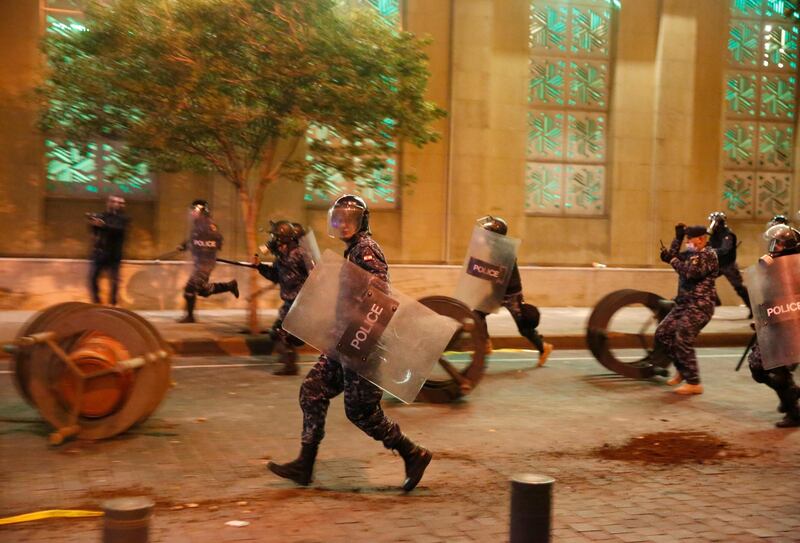 Riot policemen run after anti-government protesters trying to enter the parliament square. AP