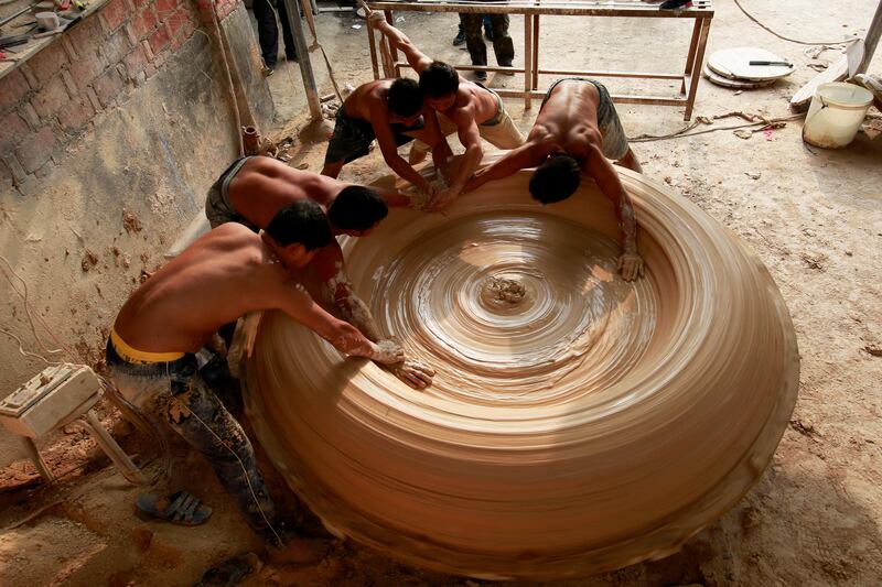 Workers make a vat at a porcelain factory in Jingdezhen, Jiangxi Province, China September 23, 2017. Picture taken September 23, 2017. REUTERS/Stringer ATTENTION EDITORS - THIS IMAGE WAS PROVIDED BY A THIRD PARTY. CHINA OUT. NO COMMERCIAL OR EDITORIAL SALES IN CHINA.     TPX IMAGES OF THE DAY