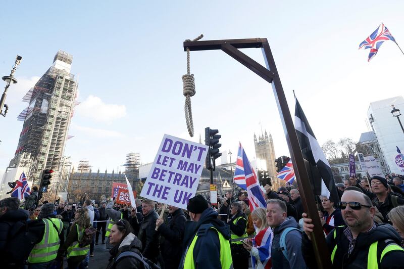 Demonstrators hold placards and flags at the "Brexit Betrayal Rally", a pro-Brexit rally, in London, Sunday Dec. 9, 2018. MP's are to vote on the EU withdrawal agreement on upcoming Tuesday. (AP Photo/Tim Ireland)