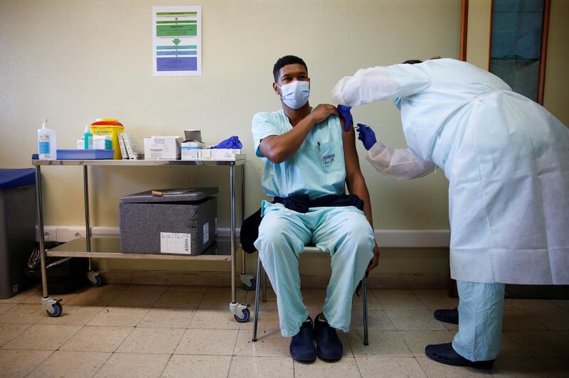 A medical worker receives the Pfizer-BioNTech coronavirus disease (COVID-19) vaccine at Santa Maria hospital in Lisbon, Portugal. Reuters