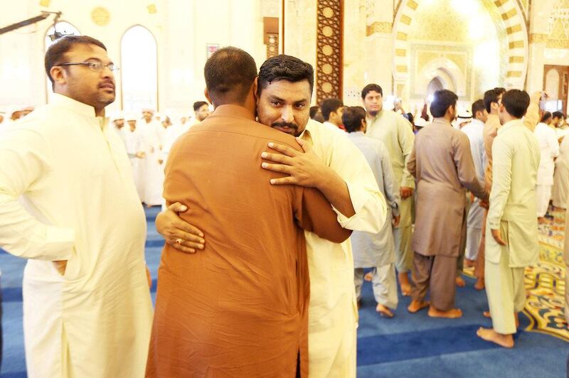People greet each other after Eid prayers at Zabeel Mosque in Dubai. Pawan Singh / The National