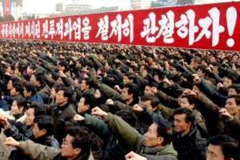 In this Korean Central News Agency photo released by Korea News Service in Tokyo on Tuesday, Jan. 6, 2009, tens of thousands of North Koreans pump their fists in unison during a rally Monday, Jan. 5, 2009 at Pyongyang's main Kim Il Sung plaza in a display of might and loyalty that underscored the regime's guiding "military first" principal amid tensions with rival South Korea. The banner means "Let's thoroughly achieve the tasks set out in this year's joint editorials," referring North Korea's three main state-run publications had issued a joint editorial on New Year's Day.  (AP Photo/Korean Central News Agency via Korea News Service) **JAPAN OUT  **