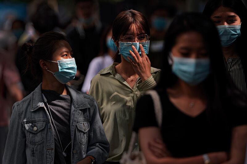 People walk during the morning rush hour in Beijing. AP