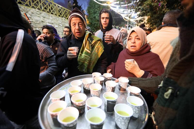 People are served free pastries, as Palestinian Muslim worshippers gather for an early morning prayer around the Ibrahimi Mosque or the Tomb of the Patriarch in Hebron, West Bank.  EPA