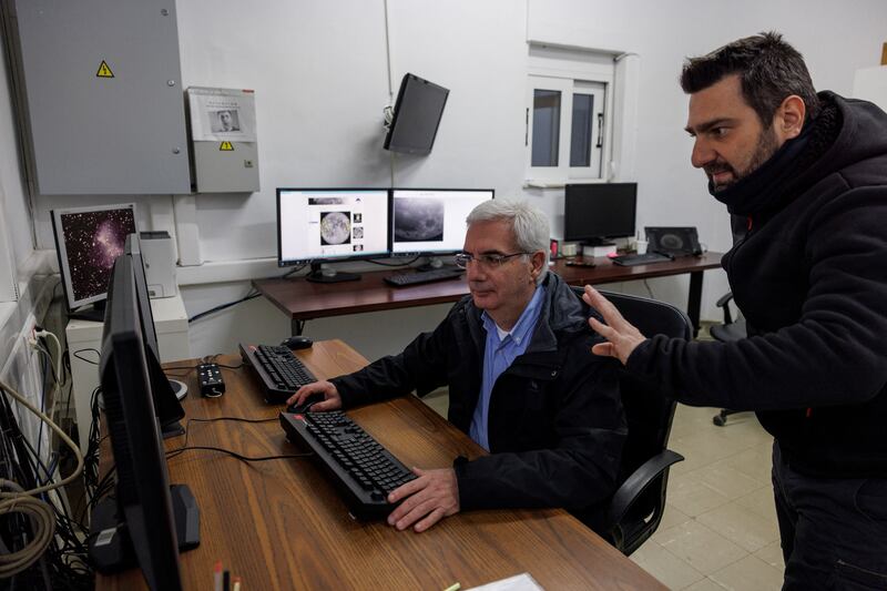 Post-doctoral researcher Alexios Liakos talks to senior researcher Manolis Xylouris as they track the comet from the Kryoneri Observatory