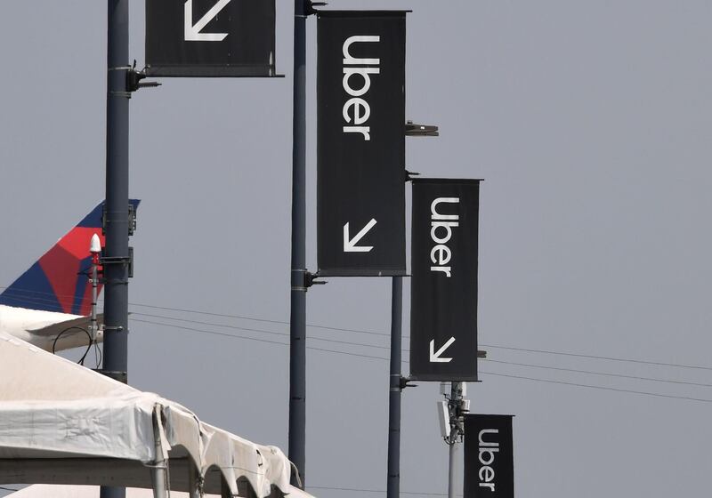 Uber signs are seen August 20, 2020 at Los Angeles International Airport in Los Angeles, California. Rideshare service rivals Uber and Lyft were given a temporary reprieve on August 20 from having to reclassify drivers as employees in their home state of California by August 21. / AFP / Robyn Beck
