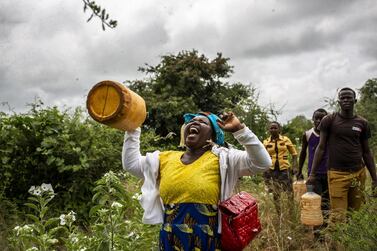 A resident shakes a bottle filled with pebbles at a swarm of desert locusts in Mathiakani, Kitui County, Kenya, on January 25. Bloomberg