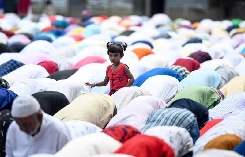 An Indian Muslim child stands as devotees offer prayers during Eid al-Fitr at the Idgah field in Guwahati. AFP