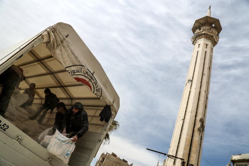 Workers unload aid from one of the 25 trucks in the aid convoy that arrived in Douma on March 15, 2018. Mohammed Badra / EPA