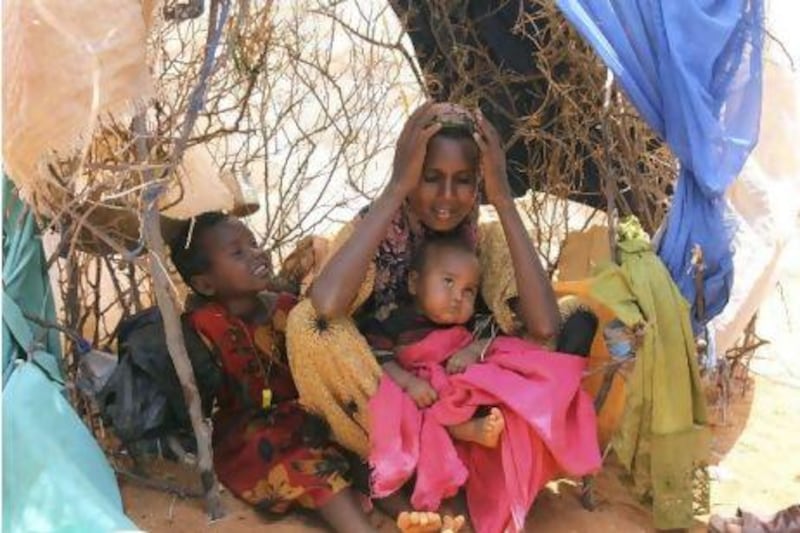 Habiba Osman Ahmed, seated with her two children in a makeshift shelter in Dollow refugee camp in southern Somalia. Khalil Senosi / AP Photo