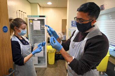 Pharmacist Naeem Khazee and nurse Jocie Walsh dilute vials of Pfizer/BioNTech’s Covid-19 vaccine at an inoculation centre in England. AFP