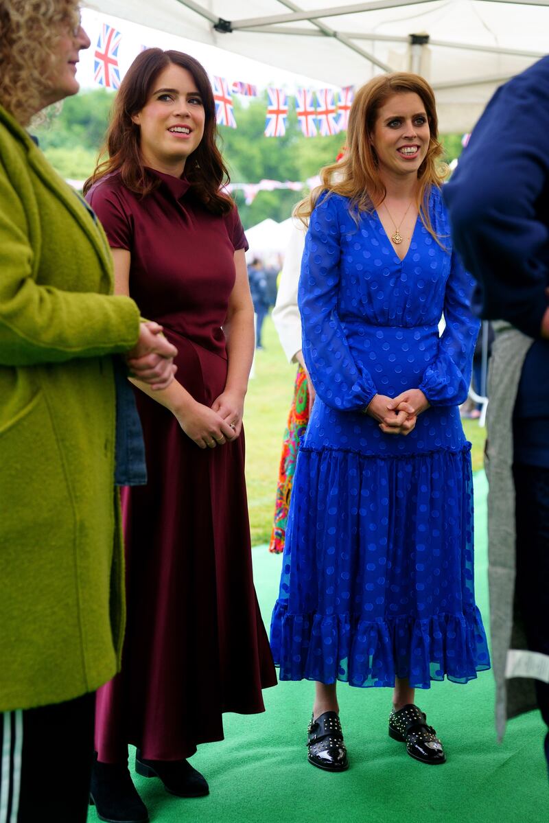Princess Eugenie, wearing a burgundy Roksanda dress, and Princess Beatrice, wearing a blue Saloni dress, attend the Big Jubilee Lunch on June 5. PA Wire