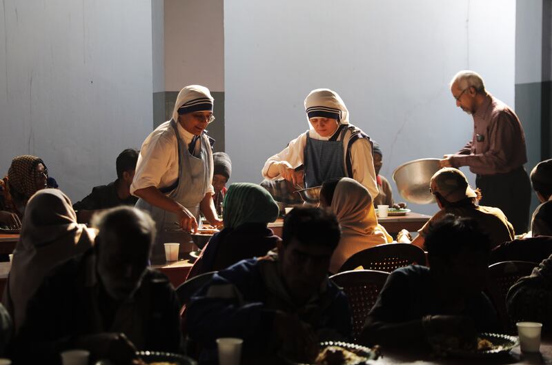 Nuns distribute food for poor people at Mother's House in Kolkata, India. EPA