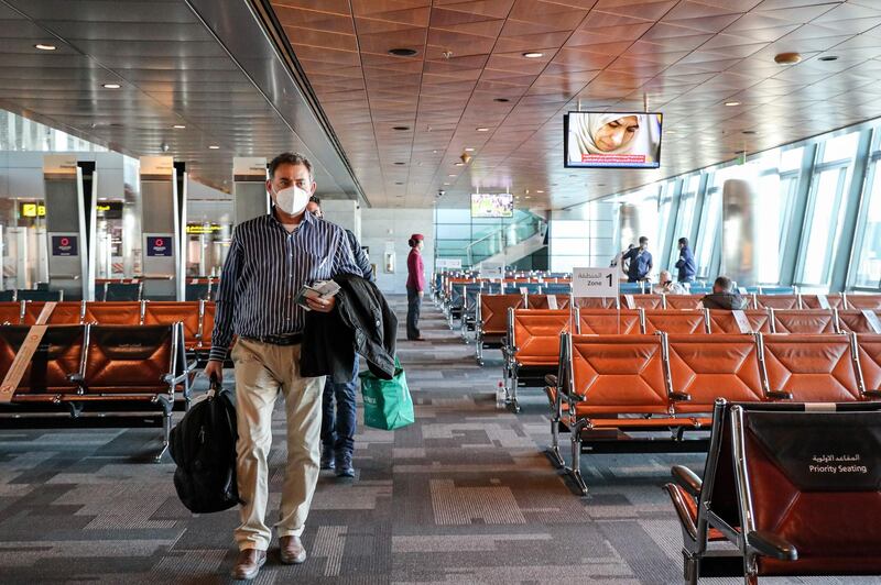 A mask-clad traveller at Doha's Hamad International Airport prepares to board the first Qatar Airways flight bound for Cairo. AFP