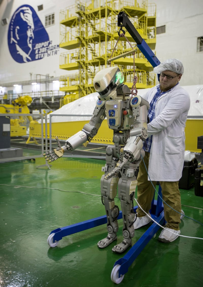 A Roscosmos employee works on the Fedor robot before it is loaded into a Soyuz capsule. AP