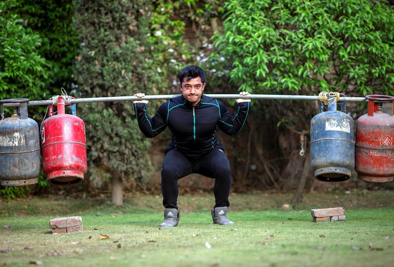 epa08340989 Nepalese body builder Nishant Pradhan works out with filled gas cylinders at his home garden during the nationwide lockdown due to the ongoing coronavirus COVID-19 pandemic in Kathmandu, Nepal, 03 April 2020. Nepalese athletes and fitness trainers have been posting various home based workout methods on their social media to maintain their fitness. Nepal is under a nationwide lockdown in an effort to slow down the spread of the pandemic COVID-19 disease caused by the SARS-CoV-2 coronavirus.  EPA-EFE/NARENDRA SHRESTHA *** Local Caption *** 56001695