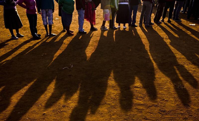 South Africans queue up to vote at a polling station that was burned down overnight, but a tent was erected to vote in the morning, in the politically-sensitive mining town of Bekkersdal, South Africa Wednesday. Ben Curtis / AP