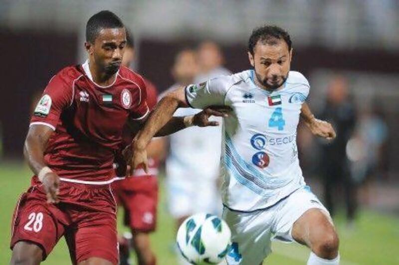 Al Wahda's Eisa Ahmed, left, and Baniyas' Ahmed Ali tussle during last night's victory for the home side at Al Nahyan Stadium. Mostafa Reda / Al Ittihad