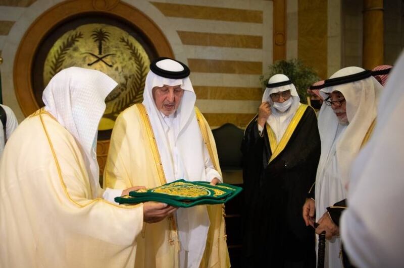 Prince Khalid Al Faisal, Governor of Makkah, hands over the new Kiswah to the Guardian of the Kaaba, Sheikh Saleh Al Shaiba, before the replacement ceremony.