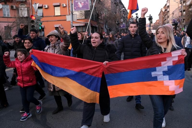 Opposition demonstrators carrying Armenian national and the separatist region of Nagorno-Karabakhâ€™s flag, right, march to the government buildings during a rally to pressure Armenian Prime Minister Nikol Pashinyan to resign in Yerevan, Armenia, Saturday, Feb. 27, 2021. The developments come after months of protests sparked by the nation's defeat in the Nagorno-Karabakh conflict with Azerbaijan. (Hrant Khachatryan/PAN Photo via AP)