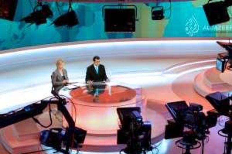 Newscasters work at the English-language newsroom at the headquarters of the Qatar-based Al Jazeera satellite channel in Doha November, 14, 2006. Arabic television station Al Jazeera launches an English-speaking channel on Wednesday to report world news from a Middle East perspective and challenge the dominance of Western media.   REUTERS/Mohammed Dubbous (QATAR)