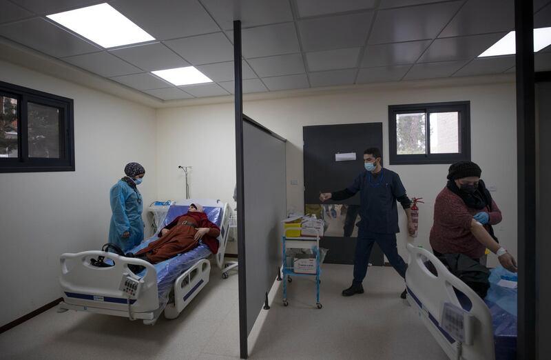 Medical staffers examine Palestinian patients infected with Covid-19 upon their admission at the emergency unit, in the Palestine Medical Complex, in the West Bank city of Ramallah. AP