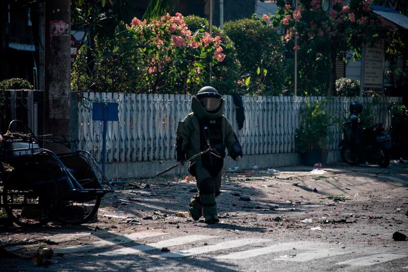 An Indonesian bomb squad member examines the site following a suicide bomb outside a church in Surabaya, East Java, Indonesia. Juni Kriswanto / AFP