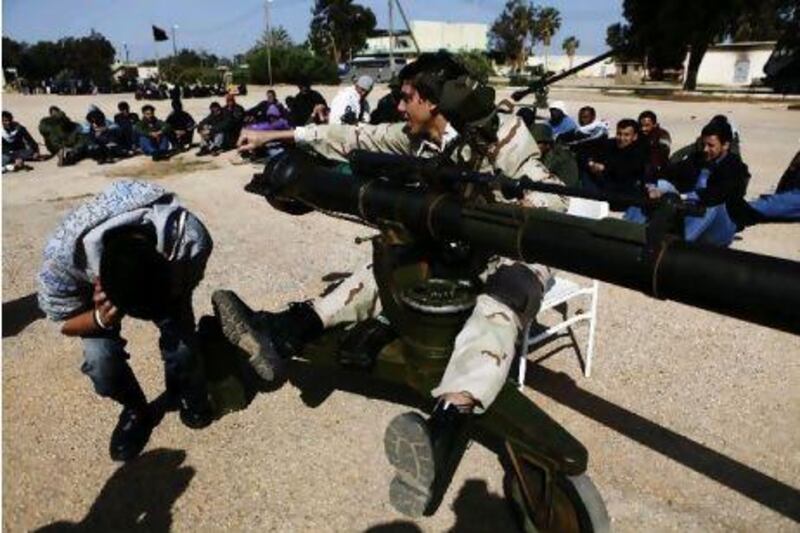 Libyan rebels teach volunteer recruits how to use an anti-aircraft gun at a base in Benghazi.