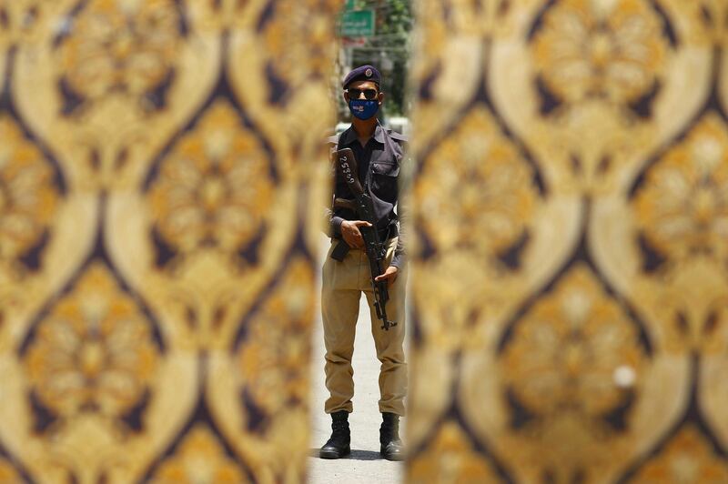 A police officer stands guard at a checkpoint of a restricted area that is sealed in smart lockdown, in Karachi, Pakistan. EPA