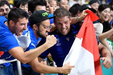 Italy lock Dean Budd, right, celebrates with supporters after victory over Canada at the Rugby World Cup in Fukuoka. AFP