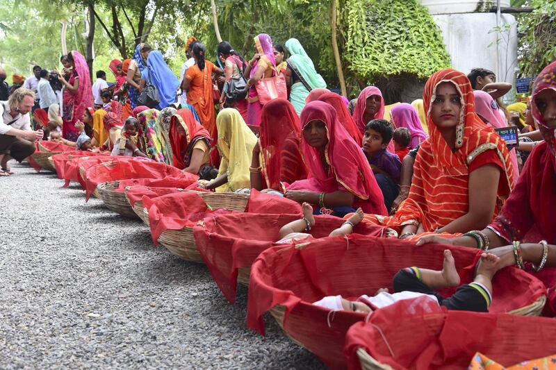 GC- Villagers plant trees to celebrate birth of girl child in Piplantri village in the desert state of Rajasthan. 
Shyam Sunder Paliwal (moustached man in white clothes and turban) seen with villagers as they celebrate 'Raksha Bandhan' by tying rakhi to plants. 
Picture credit- Prem Shankar