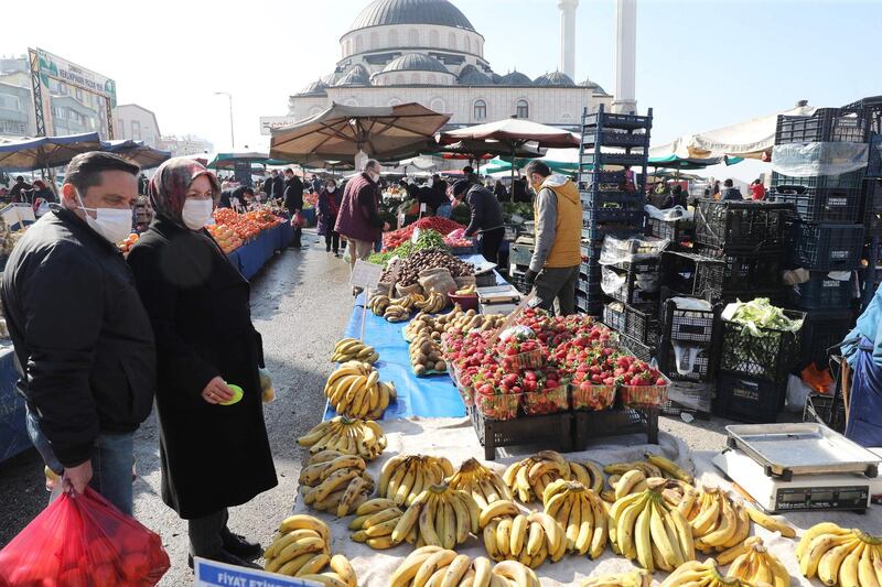 People wearing protective masks shop at a local market, amid the coronavirus disease (COVID-19) outbreak in Ankara on February 22, 2021.  Ankara residents shop in the open markets although more and more Turks are finding it difficult to cope with growing poverty and the sometimes daily rise in prices. / AFP / Adem ALTAN
