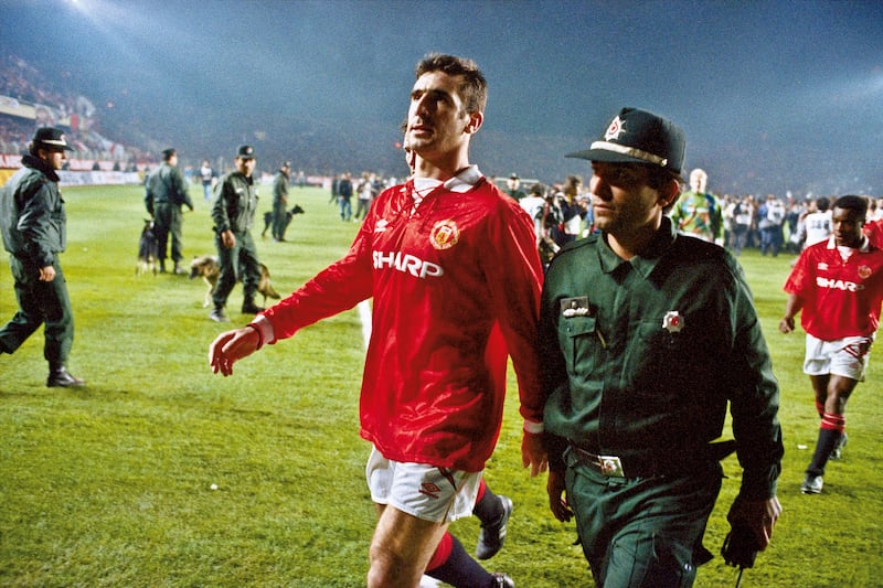 Manchester United player Eric Cantona is escorted from the pitch by a policeman after he was sent off at the end of the Champions League second round match with Galatasaray at the Ali Sami Yen stadium, Istanbul, on November 3, 1993. Getty Images