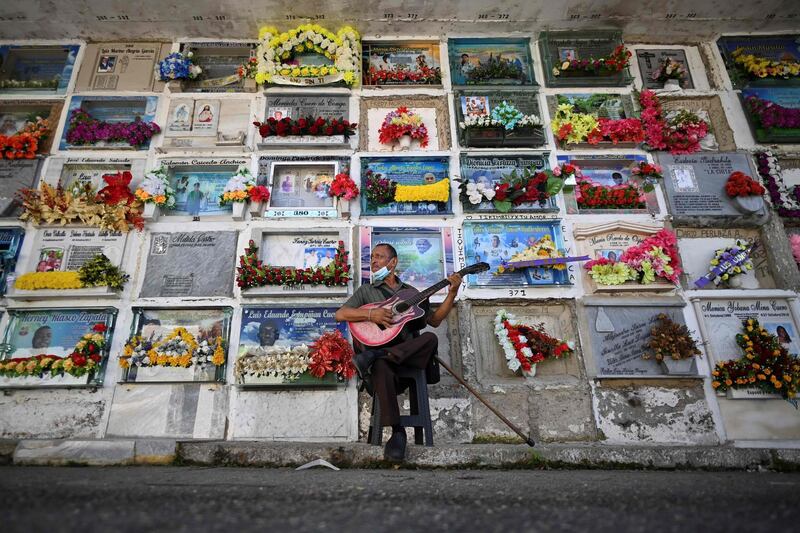 Javier Giraldo, 57, who has played his guitar at funerals for the past 30 years, performs at a cemetery in Buenaventura, Colombia. Since December, the city has been suffering the effects of violence between two factions of armed group La Local, which are fighting for control of drug trafficking. AFP