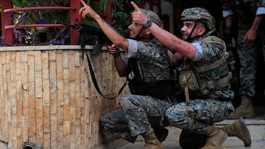 Lebanese security forces react to gunfire during a protest in Beirut, Lebanon, Thursday, Oct.  14, 2021.  Armed clashes broke out in Beirut Thursday during a protest against the lead judge investigating last year’s massive blast in the city's port, as tensions over the domestic probe boiled over.   (AP Photo / Hussein Malla)