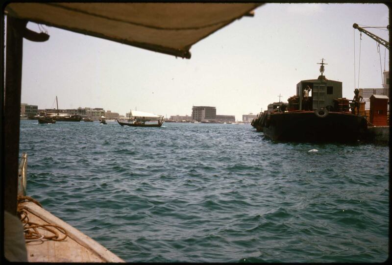Travelling across Dubai Creek the traditional way. A Gray Mackenzie and Co barge, right, carried goods from ships offshore to customs on the quayside