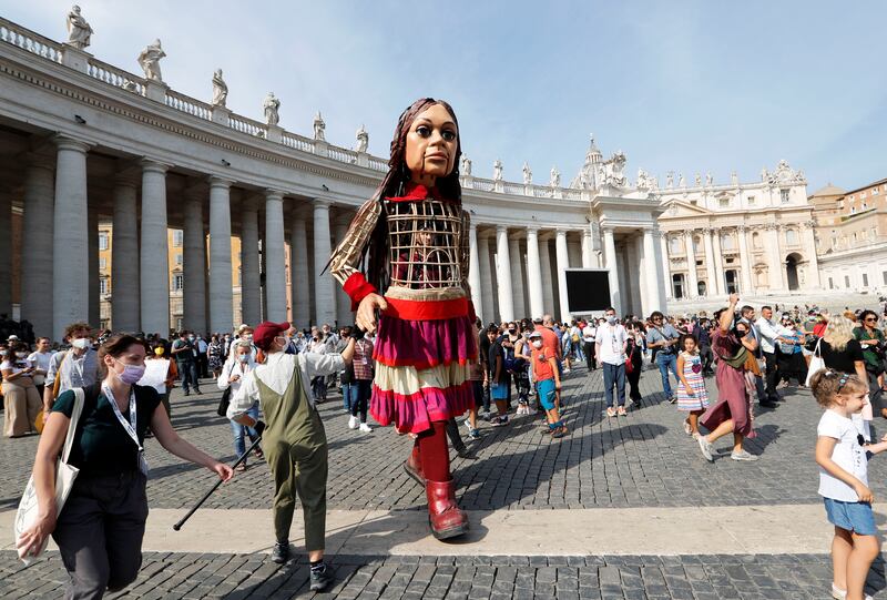 Little Amal, a 3. 5 metre tall puppet of a young Syrian refugee girl, is greeted in the Vatican as she travels across Europe from Turkey to Britain as part of an 8,000 kilometre walk to raise awareness for the plight of young refugees, Vatican, September 10, 2021.  REUTERS / Remo Casilli