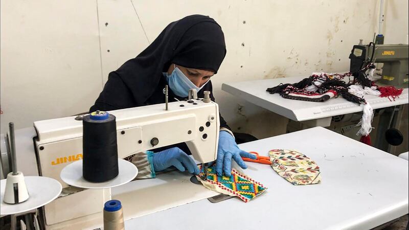 The beading takes up to two days to compete, and the women wear PPE while sewing the masks, which are washed before they are sold. AFP