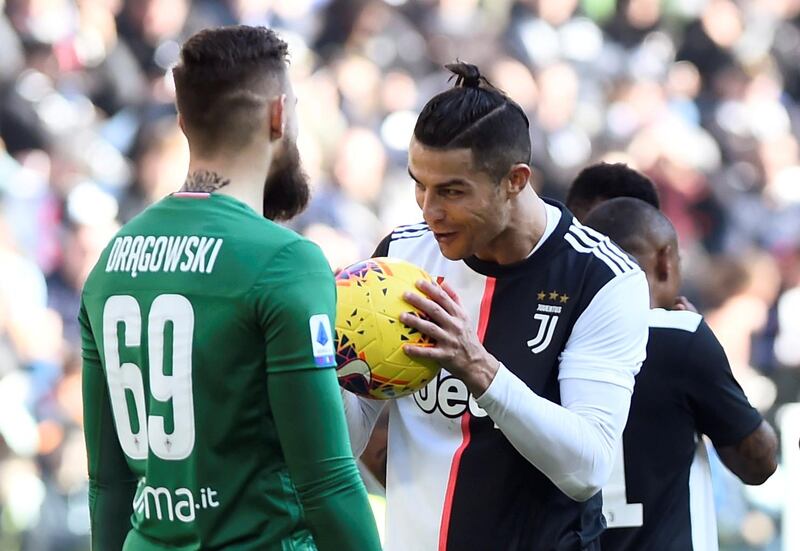 Juventus' Cristiano Ronaldo talks to Fiorentina's Bartlomiej Dragowski before taking a penalty. Reuters