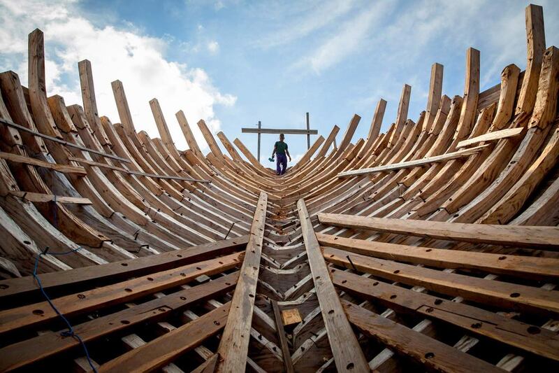 A Buginese starts to install a wooden block in the hull of a phinisi in South Sulawesi, Indonesia. Phinisi is a traditional wooden two-masted sailing ship, well-known as the traditional sea transportation amongst the Buginese people for many centuries. Agung Parameswara / Getty Images