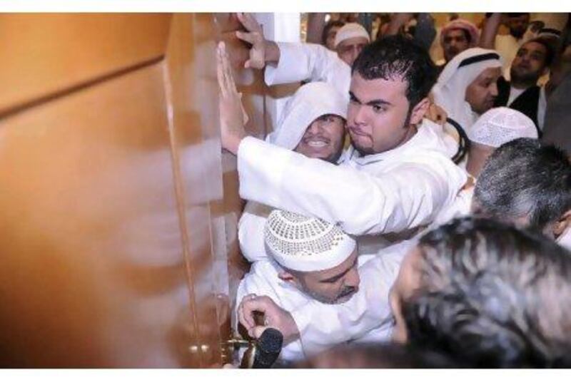 Protesters force open the door of the National Assembly Debate hall during a demonstration in Kuwait City on Wednesday.