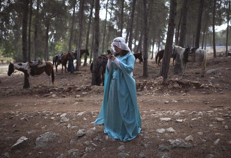 An enthusiast wearing a costume looks at her mobile phone during a re-enactment of a decisive Crusaders battle in occupied Palestine’s Galilee region July 5, 2014. About 50 people participated in the re-enactment of the Battle of the Horns of Hattin, where Muslim forces led by the legendary Salah al-Din defeated Christian fighters in the late 12th century.  Reuters