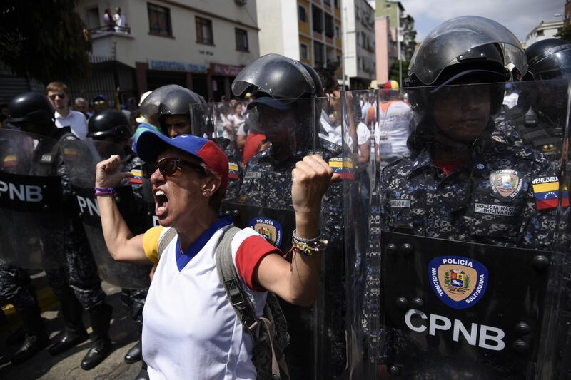 A protester shouts at Bolivarian National Police officers during an anti-government rally in Caracas, Venezuela. Bloomberg