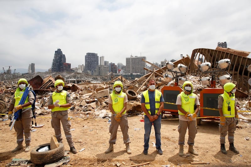 Workers line at the devastated site of the explosion at the port of Beirut.  EPA