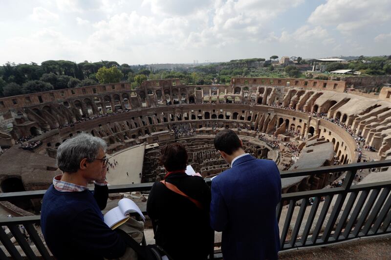 Journalists look out from topmost level of the ancient Colosseum. Andrew Medichini / AP Photo